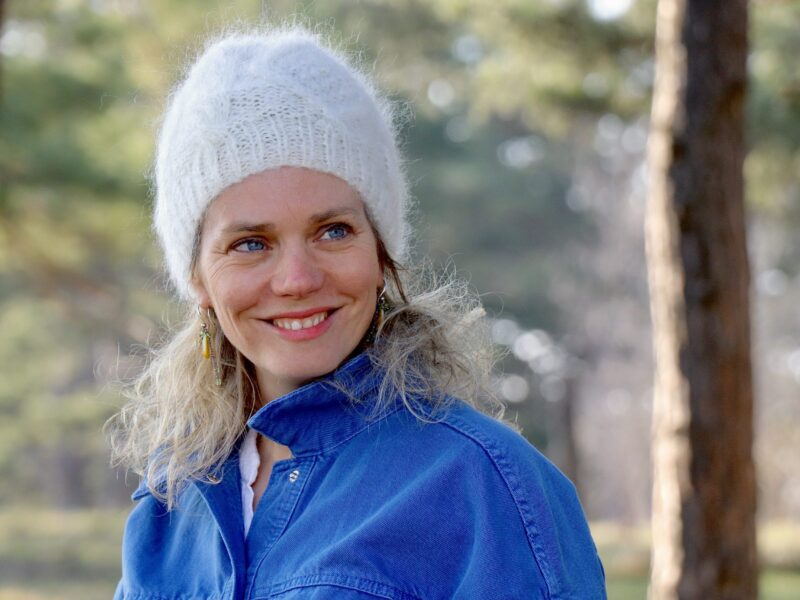 bonnet en mohair écru et torsades sur mannequin de face en portrait en forêt